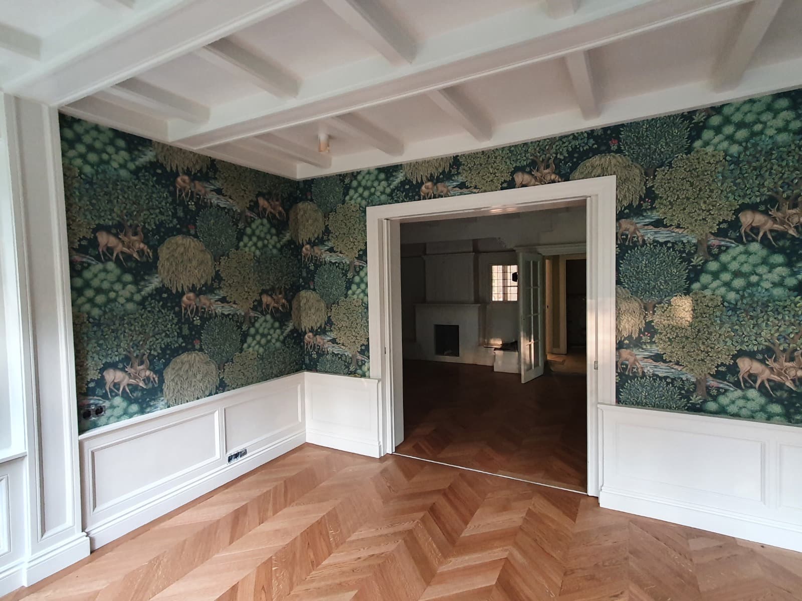Herenhuis met patroonbehang en strak gelakte lambrisering